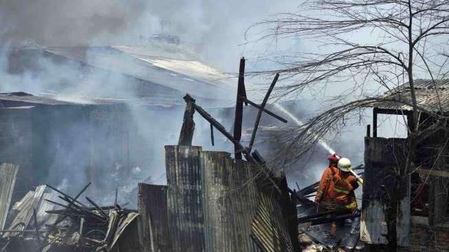 Petugas pemadam kebakaran memadamkan api yang membakar sejumlah rumah warga di kawasan Cipinang Besar Utara, Jatinegara, Jakarta Timur, Rabu (24/9). [Antara/Widodo S. Jusuf]