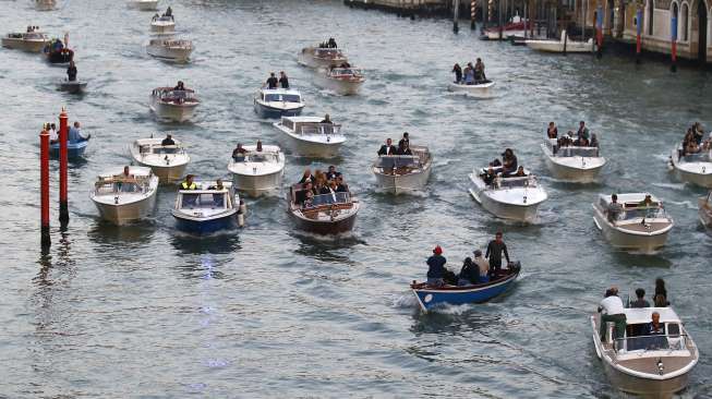 George Clooney berkeliling di Grand Canal, Venesia dengan menaiki 'taxi boat', sebelum resepsi pernikahannya, Sabtu (27/9/2014). (Reuters/Stefano Rellandini)