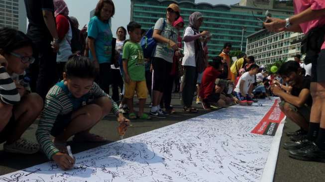 Warga bubuhkan tanta tangan menolak Pilkada lewat DPRD di acara Car Free Day, Bundaran HI, Jakarta [suara.com/Bowo Raharjo]