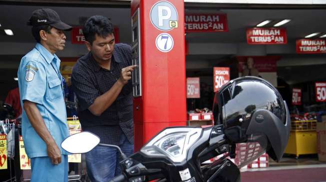 Pengendara melakukan transaksi parkir dengan mesin parkir meter di Jalan Sabang Jakarta Pusat, Selasa (30/9). [suara.com/Kurniawan Mas'ud]