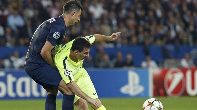 Pemain Paris St Germain Thiago Motta (kiri) menahan pemain Barcelona Lionel Messi mengejar bola.(REUTERS/Benoit Tessier)