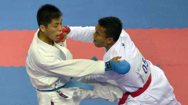 Karateka Indonesia Jintar Simanjuntak (kanan) melepaskan pukulan ke Karateka Korea Utara, Songji Kang (bawah) pada seperdelapan final Komite Putra -67 kg Asian Games ke-17 di Gyeyang Gymnasium, Incheon, Korsel, Kamis (2/10). [Antara/Saptono]