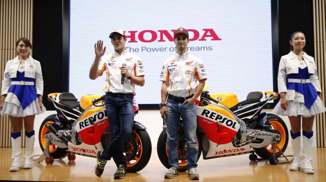 Dua pebalap MotoGP dari tim Repsol Honda, Marc Marquez (dua dari kiri) dan Dani Pedrosa, berpose bersama motor mereka di kantor Honda Motor Co di Tokyo, Rabu (8/10/2014). [Reuters/Toru Hanai]