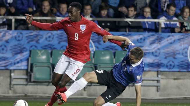 Pemain Estonia mencoba menghentikan laju striker Inggris Danny Welbeck (kiri) [Reuters/Ints Kalnins]