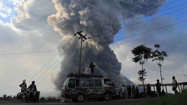 Gunung Sinabung kembali meletus di DesaTiga Pancur, Simpang Empat, Karo, Sumut, Senin (13/10). Letusan yang mengeluarkan material vulkanik disertai suara gemuruh. [Antara/Septianda Perdana]