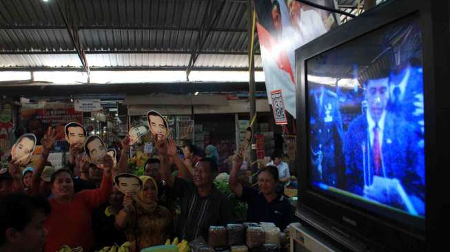 Sejumlah pedagang dan pengunjung menonton bersama melalui TV acara pelantikan Presiden, Joko Widodo dan wakilnya, Jusuf Kalla di Pasar Gede, Solo, Jawa Tengah, Senin (20/10). 