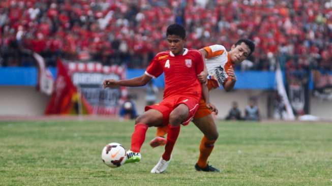 Pemain Persis Solo Hendri Apriliyanto (4) saat berebut bola dengan Arie Supriyatna dari Pusamania Borneo FC di Stadion Manahan, Solo. (ANTARA FOTO/Andika Betha)