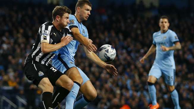 Striker Manchester City Edin Dzeko (tengah) ditempel ketat pemain Newcastle United Paul Dummett, (29/10/2014).(REUTERS/Darren Staples)