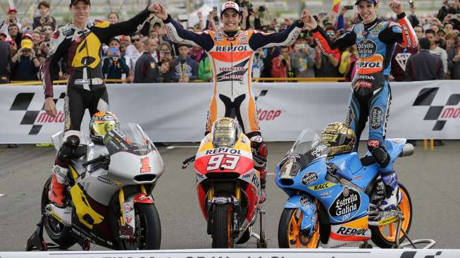 Juara Dunia MotoGP Marc Marquez (tengah), Moto2 Esteve Rabat (kiri), dan Alex Marquez Moto3 berpose di akhir Grand Prix di Ricardo Tormo, Valencia, Spanyo, (9/11). (Reuters/Heino Kalis)