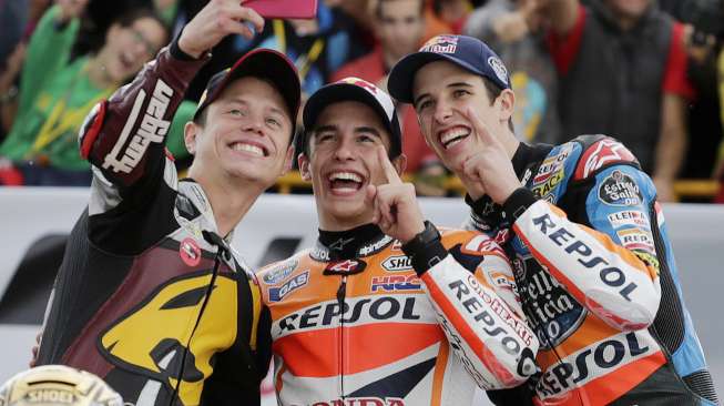 Juara Dunia MotoGP Marc Marquez (tengah), Moto2 Esteve Rabat (kiri), dan Alex Marquez Moto3 berpose di akhir Grand Prix di Ricardo Tormo, Valencia, Spanyo, (9/11). (Reuters/Heino Kalis)