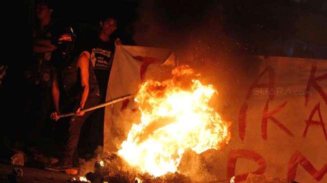 Aksi sejumlah aktivis Himpunan Mahasiswa Islam (HMI) yang berunjuk rasa menolak kenaikan harga BBM bersubsidi, di kawasan Cikini, Jakarta, Senin (17/11/2014) malam. [Suara.com/Kurniawan Mas'ud]