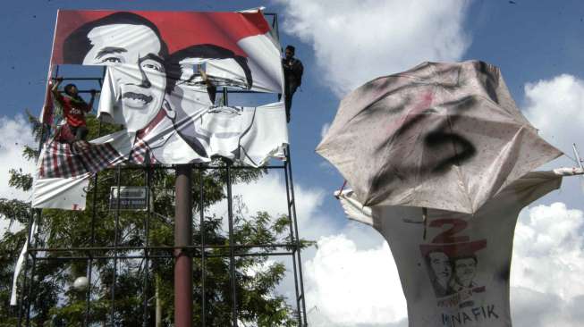 Gerakan mahasiswa Sumbar menurunkan baliho Jokowi - JK saat berunjuk rasa di Padang, Sumatera Barat, Selasa (18/11). [Antara/Maril Gafur]