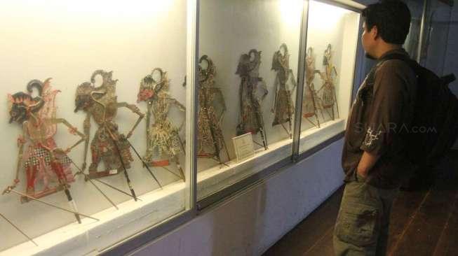 Pengunjung melintas di depan koleksi wayang di Museum Wayang kawasan Kota Tua Jakarta,Sabtu (6/12).