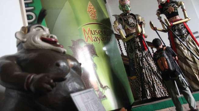 Pengunjung melintas di depan koleksi wayang di Museum Wayang kawasan Kota Tua Jakarta,Sabtu (6/12). [suara.com/Oke Atmaja]