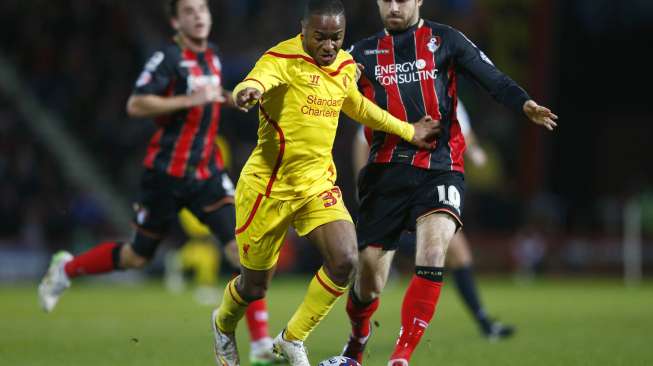 Pemain Liverpool Raheem Sterling mencoba melewati hadangan pemain Bournemouth Brett Pitman (kanan). REUTERS/Andrew Winning