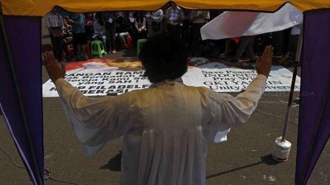 Menjelang Natal, Jemaat GKI Yasmin Bogor dan HKBP Filadelfia Bekasi, Jawa Barat, menggelar ibadah di depan Istana Merdeka,RI Jakarta, Minggu (21/12). [suara.com/Kurniawan Mas'ud]