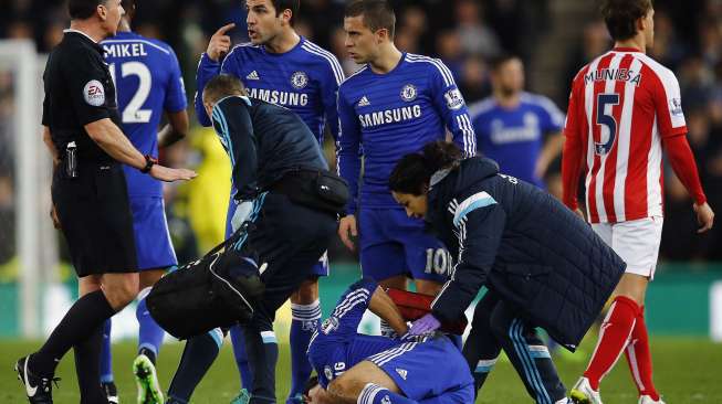 Pemain Chelsea Cesc Fabregas berbicara kepada wasit Neil Swarbrick saat Diego Costa mendapat perawatan dari tim medis [Reuters/Darren Staples]