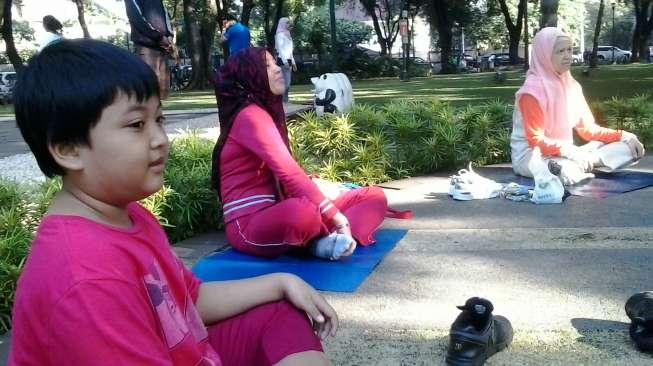 Orang dewasa dan anak-anak banyak yang bergabung di Komunitas Falun Dafa untuk meditasi setiap minggu pagi di Taman Suropati, Jakarta. (suara.com/Firsta Nodia)