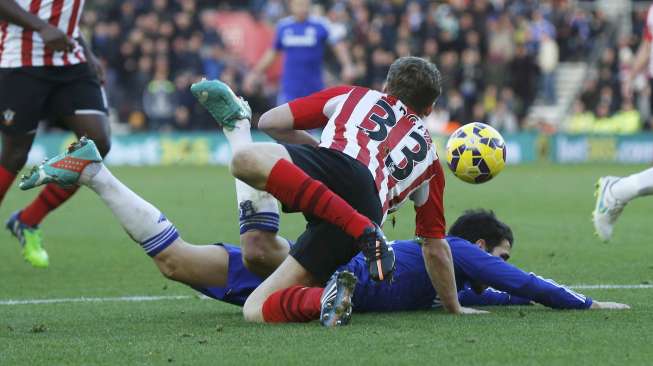 Gelandang Chelsea Cesc Fabregas dijatuhkan oleh pemain Southampton Matt Targett di St Mary's Stadium. REUTERS/Suzanne Plunkett