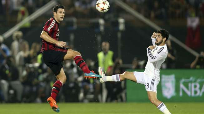 Pemain Real Madrid Isco (kanan) memperebutkan bola dengan pemain AC Milan Daniele Bonera di Dubai (30/12). REUTERS/Stringer/SPORT SOCCER