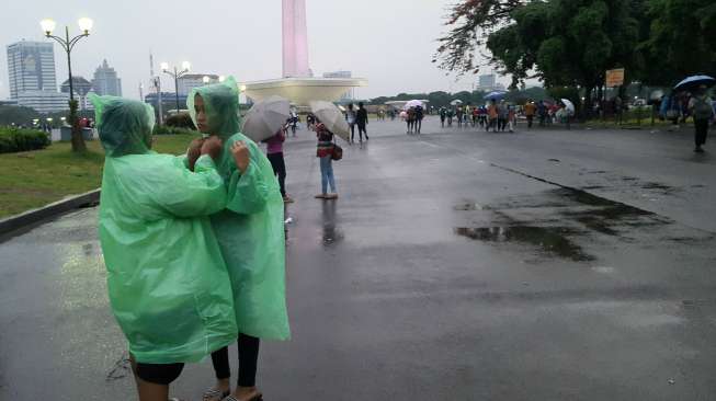 Monas Diguyur Hujan, Pedagang Jas Hujan Menangguk Untung