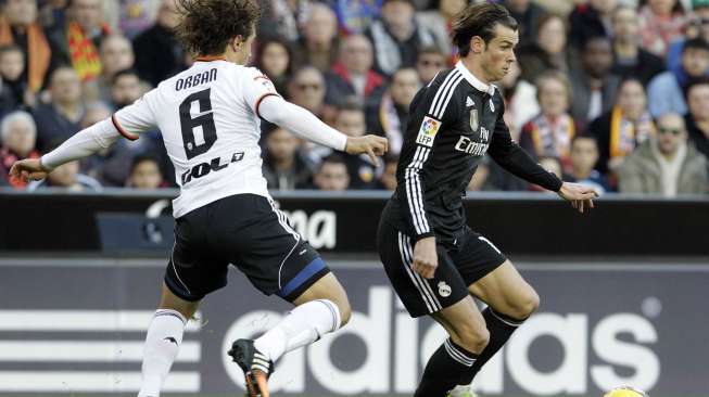 Pemain Valencia (kiri) mencoba menghadang winger Real Madrid Gareth Bale di Mestalla. REUTERS/Stringer