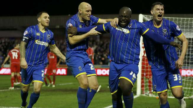 Pemain AFC Wimbledon's Adebayo Akinfenwa (kedua kanan) merayakan golnya ke gawang Liverpool bersama rekan setimnya di Kingsmeadow Stadium, REUTERS/Stefan Wermuth