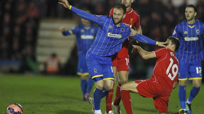 Pemain AFC Wimbledon Sean Rigg (kiri) melanggar pemain Liverpool Javi Manquillo (kanan) di Kingsmeadow Stadium. REUTERS/Stefan Wermuth