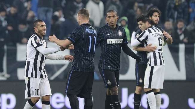 Striker Juventus Carlos Tevez (kiri) dan pemain baru Inter Milan Lukas Podolski berjabat tangan usai laga yang berakhir imbang 1-1.REUTERS/Giorgio Perottino