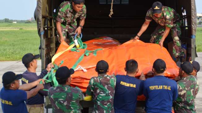 Sejumlah penyelam mengangkat balon berukuran besar milik TNI AL, di Base Ops Lanudal Juanda, Kamis (8/1/2015), yang akan digunakan untuk mengevakuasi ekor pesawat AirAsia QZ8501 di Selat Karimata. [Antara/Eric Ireng]