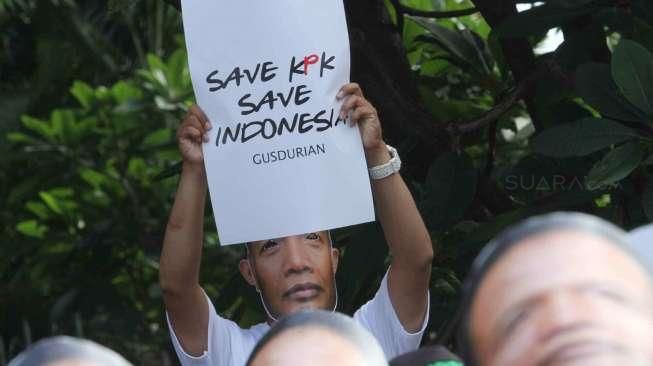 Ratusan orang berpakaian putih memberikan petisi di sebuah spanduk dengan tulisan #saveKPK pada acara car free day di Bundaran HI, Jakarta, Minggu (25/1). [suara.com/Oke Atmaja]