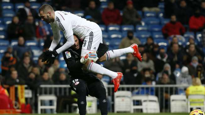 Pemain Real Madrid Karim Benzema (kanan) menabrak kiper Sevilla Beto di Santiago Bernabeu. REUTERS/Susana Vera