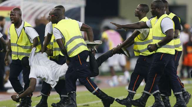 Petugas kemenangan mengamankan suporter Guinea Ekuatorial yang masuk ke dalam lapangan. REUTERS/Amr Abdallah Dalsh