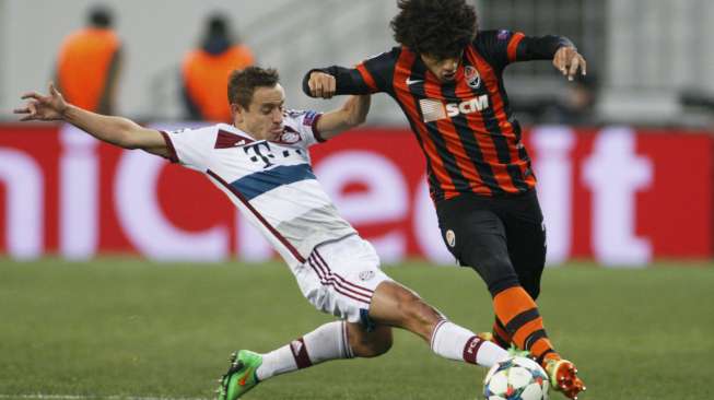 Pemain Shakhtar Donetsk Taison (kanan) membawa bola dan coba direbut pemain Bayern Munich Rafinha. REUTERS/Valentyn Ogirenko