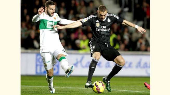 Pemain Real Madrid, Karim Benzema (kanan), saat berebut bola dengan pemain Elche, David Lomban, dalam pertandingan Liga Spanyol, Minggu (22/2/2015). [Reuters/Heino Kalis]