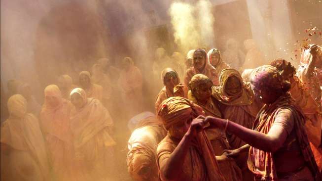 Sekelompok janda menari bersama, sebagai bagian dari perayaan Holi yang digelar sebuah LSM di asrama mereka di Vrindavan, Uttar Pradesh, India, Jumat (6/3/2015). [Reuters/Ahmad Masood]