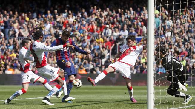 Pemain Barcelona Gerard Pique mencetak gol ke gawang Rayo Vallecano (8/3) [Reuters/Albert Gea]