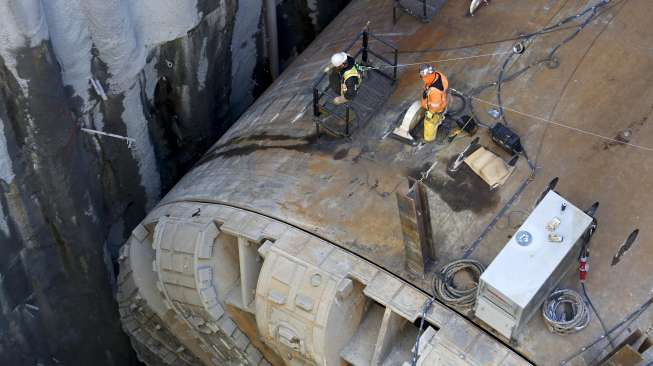 Sejumlah pekerja sibuk mengangkat mata pisau Bertha, mesin bor terbesar di dunia, untuk diperbaiki di Seattle, Washington, Amerika Serikat, (9/3/2015). [Reuters/Jason Redmond]