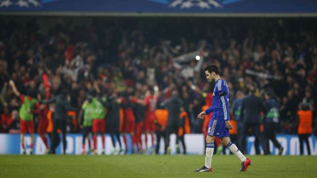 Gelandang Chelsea, Cesc Fabregas, tertunduk lesu sementara di belakangnya para pemain PSG bergembira merayakan keberhasilannya menembus perempat final Liga Champions (Reuters/John Sibley).