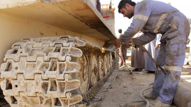 Para montir memperbaiki tank-tank tua di Duldul, Basra, Irak, untuk kembali dipakai memperkuat militer Irak, (4/3). (Reuters/Essam Al Sudani)