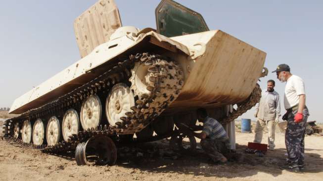 Para montir memperbaiki tank-tank tua di Duldul, Basra, Irak, untuk kembali dipakai memperkuat militer Irak, (4/3). (Reuters/Essam Al Sudani)