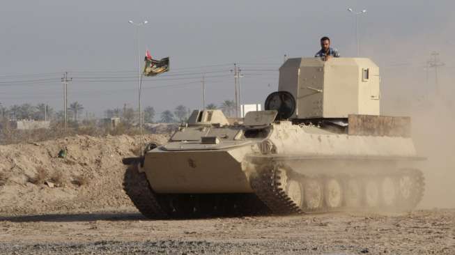 Para montir memperbaiki tank-tank tua di Duldul, Basra, Irak, untuk kembali dipakai memperkuat militer Irak, (4/3). (Reuters/Essam Al Sudani)