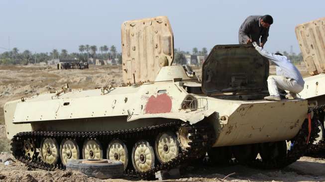 Para montir memperbaiki tank-tank tua di Duldul, Basra, Irak, untuk kembali dipakai memperkuat militer Irak, (4/3). (Reuters/Essam Al Sudani)