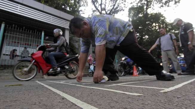 Aktivis dari kelompok Koalisi Pejalan Kaki membuat zebra cross di depan Stasiun Sudirman Jakarta, Jumat (13/3). (Suara.com/Kurniawan Mas'ud)