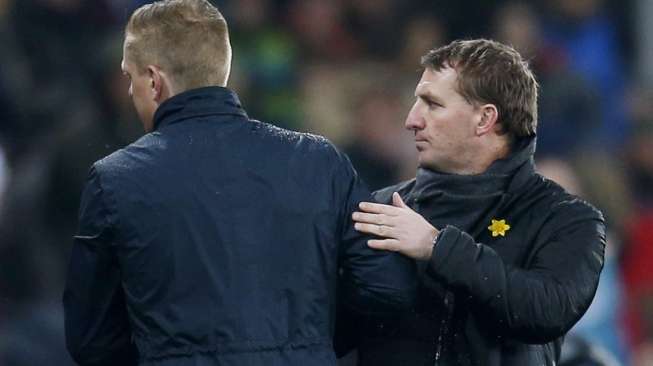 Manajer Liverpool Brendan Rodgers (kanan) bersalaman dengan manajer Swansea Garry Monk usai pertandingan (17/3) [Reuters/Andrew Couldridge]