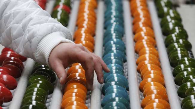 Telur-telur matang dalam proses pewarnaan di sebuah pabrik produsen telur berwarna Schrall di Desa Diendorf, Austria, (16/3). [Reuters/Leonhard Foeger]