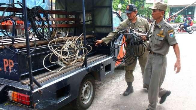 Petugas Kecamatan Johar Baru, Jakarta Pusat bersama petugas dari Perusahaan Listrik Negara (PLN) mengadakan razia sambungan listrik di kawasan Johar Baru, Jakpus. (25/3). (Suara.com/Oke Atmaja)