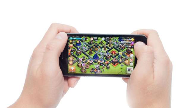 Ilustrasi pengguna smartphone memainkan game Clash of Clans (Shutterstock).