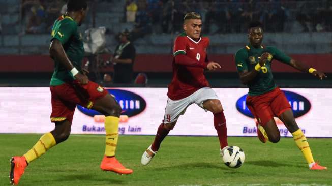 Timnas Indonesia senior Alfero Gonzales (tengah) berusaha menggiring bola, melintasi pesepak bola Timnas Kamerun Ngerni Ndasi Kadiang (kiri) dan Oyongo Bitolo (kanan) pada laga persahabatan di Stadion Gelora Delta Sidoarjo, Jawa Timur, Rabu (25/3)