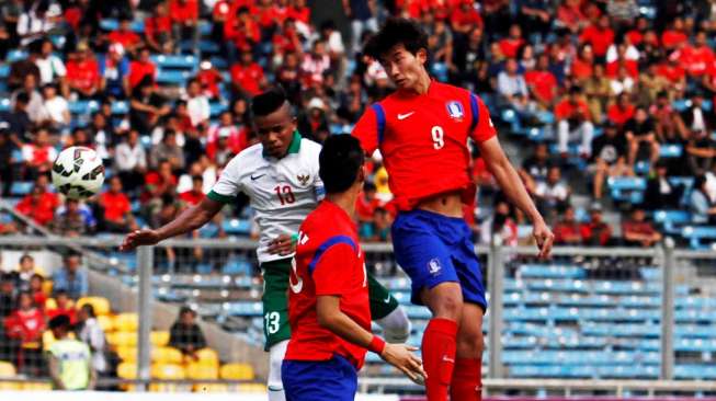 Kapten Timnas Indonesia U-23, Manahati Lestusen berebut bola di udara dengan dua pemain Korea Selatan. [suara.com/Kurniawan Mas'ud]